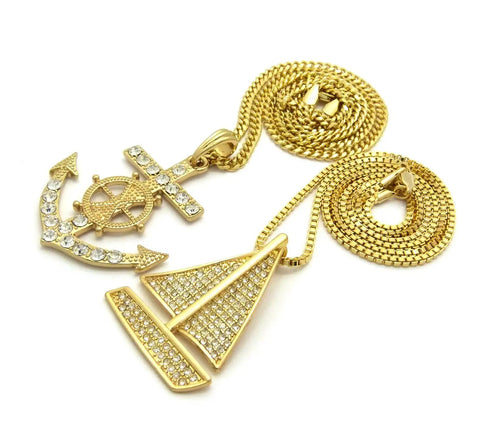 Dope Iced Out Sailboat Yacht And Anchor Pendant Necklace Set In Gold Tone With Two Necklace Set And Layered Chains Including 20 Inch Box Chain And 24 Inch Cuban Chain Plus 30 Inch Long Option For Maximum Bling. Image shows gold-tone sailboat and anchor pendants with chains.