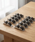 10 Pack Heavy Duty Mini Furniture Casters That Roll Like A Dream With Silent TPE Pads For Tool Benches Cabinet Drawers And Office Desks on wooden surface.