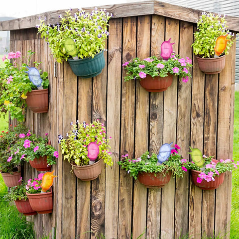 Eight Pack Self Watering Spikes For Plants With 60ml Bird Shape Automatic Watering Globes on wall with potted flowers