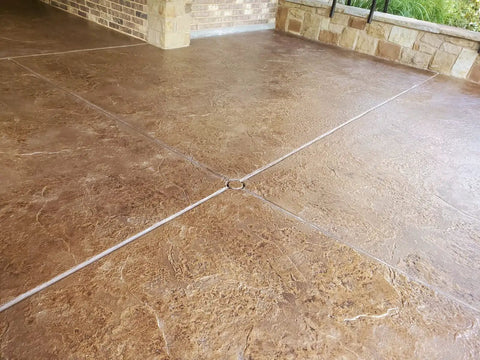 Heavy Duty Wet Look Concrete Sealant High Gloss Water Repellent Coating For Masonry Stone Slate Tile UV Resistant Water Based Formula applied on a textured brown concrete surface.