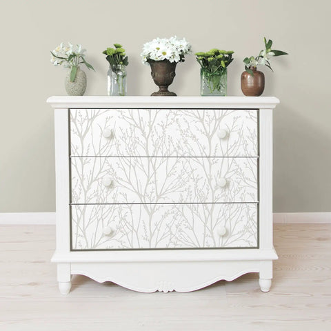 Dresser with Treetops Peel And Stick Wallpaper In White And Off White, featuring tree motif design for easy DIY decor; flowers on top