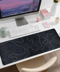 Large Topographic Gaming Mouse Pad 31.5 By 11.8 Inches With Smooth Surface Grippy Non Slip Base And Stitched Edge Extended Desk Pad XL Desk Mat For Gaming And Work Black on desk with keyboard and computer monitor
