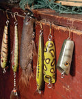 Handcrafted wooden fishing lures on display, showcasing colors and designs for use in DIY Wooden Fishing Lure Crafting And Painting Guide Featuring 11 Proven Designs For Crankbaits Swimmers And Poppers So You Can Kick Tail On Finicky Fish Near Shore Or Deep.