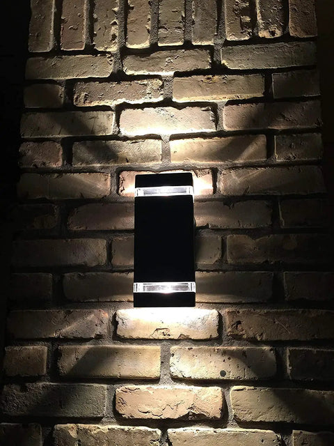 Square Up And Down LED Outdoor Wall Light With Die Cast Aluminum Housing Weatherproof Rugged Exterior Wall Lamp 3000K Warm White 5W ETL Listed Built To Last Outdoor Use mounted on brick wall, emitting warm light in both directions.