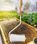 Pro Grade Honey Uncapping Roller Tool for Beekeepers, sharp plastic prongs in use on honeycomb frame with bees