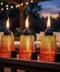 Citronella Glass Table Top Torches For Outdoor Patio 16oz Set Of 3 red, yellow, and orange decorative torch candles lit on a deck.