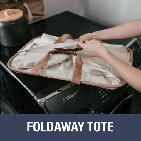 Collapsible Laundry Tote Two Pack 50L folded on washing machine, cream cotton blend, vegan leather accents, easy storage.