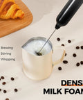 Rechargeable Handheld Milk Frother With USB Type C 3 Speed Adjustable Foam Maker whipping milk in a white jug on a table