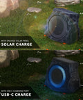 Two Pack Solar Powered Rock Speakers With Lit RGB Lights IP44 Water Resistant Outdoor Speakers For Patio Pool Party Yard Garden USB Rechargeable And USB Charging displayed on grass with solar panels and USB port.