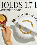 White and gold electric kettle with lemon tea, top view, showing sleek design and holding 1.7L. High Temperature Control Electric Kettle With 1500W Rapid Boil And Keep Warm Function Glass Body BPA Free Design White And Gold Finish Auto Shut Off Sleek Modern Design For Tea Lovers And Daily Hydration.
