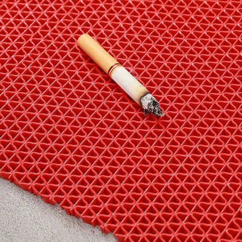 Red drainage flooring with a cigarette on top, showcasing slip resistance and non-slip surface design