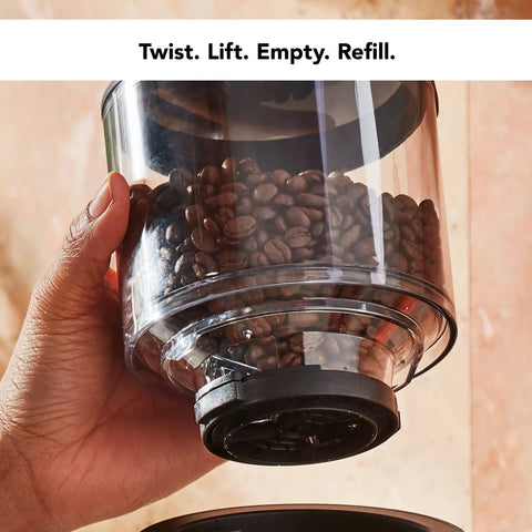 Hand holding container of Smart Dosing Burr Coffee Grinder KCG8433 Black Matte Delivers Consistent Grind Size For Every Brew