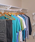 Expandable Closet Shelf And Hanging Rod System Adjustable From 17.5 To 27 Inches White Finish Holds Up To 200 Lbs displayed with clothes