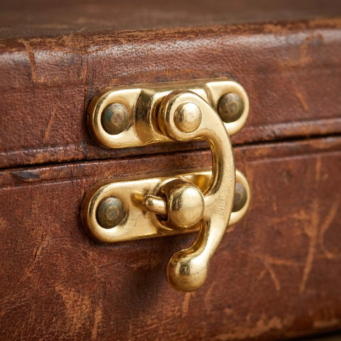Retro Vintage Swing Bag Clasp Closure Lock Latch for furniture and wooden boxes, showing antique gold iron catch on brown surface.