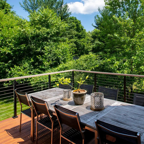 1/8 Inch T316 Stainless Aircraft Cable 300 Feet For Railing Decking And Outdoor Projects Uncoated Marine Grade 1800 Lbs Breaking Strength Durable 7x7 Braided Cable shown on a wooden deck with greenery.