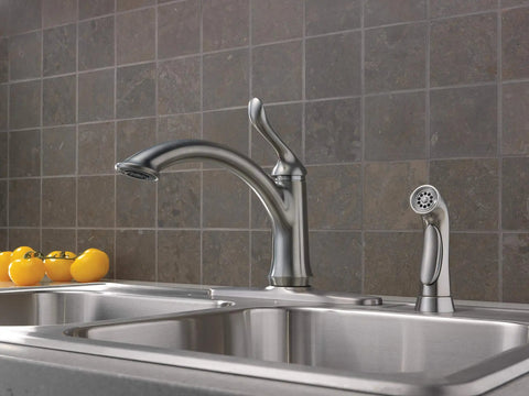 Linden Single-Handle Kitchen Faucet With Side Sprayer in brushed nickel installed on modern sink with tiled backsplash.