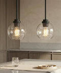 Straight Up Matte Black Globe Pendant Lights 2 Pack With Clear Glass Shades and Corrosion Resistant Metal Base above kitchen island.