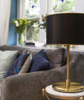 Dope Black Drum Lampshade With Spider Fitter And Harp Compatibility, 13 Inch Diameter And 8.5 Inch Height on a table lamp in room.