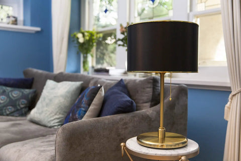 Dope Black Drum Lampshade With Spider Fitter And Harp Compatibility, 13 Inch Diameter And 8.5 Inch Height on a table lamp in room.