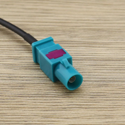 Close-up of Fakra Z Male To Male Vehicle Antenna Adapter Cable 30 cm RG174 coax connector on wood surface, used for DAB GPS FM.