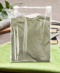 Clear Poly Bags For Clothes Set Of 70 12x16 Inches Resealable Shirt Bags For T Shirts Hoodies And Garments Great For Gift Wrapping Party Favors Artwork Protectors Decorative Wrappers Transparent Packaging containing a folded green shirt