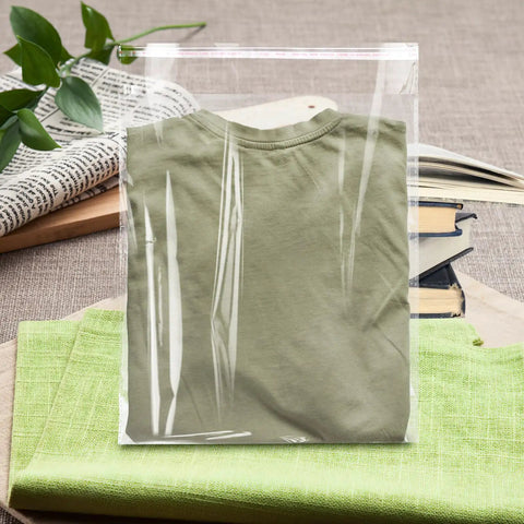 Clear Poly Bags For Clothes Set Of 70 12x16 Inches Resealable Shirt Bags For T Shirts Hoodies And Garments Great For Gift Wrapping Party Favors Artwork Protectors Decorative Wrappers Transparent Packaging containing a folded green shirt
