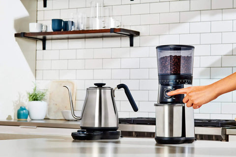 Gooseneck Electric Kettle For Pour Over Coffee And Tea With Dialed In Temperature In One Degree Increments From 104 To 212 Fahrenheit And 40 To 100 Celsius Built In Brew Timer Stainless Steel 1 Liter on a kitchen counter next to a coffee grinder.