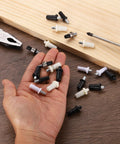 Hand holding Rock Solid Spring Loaded Shutter Repair Pins 80 Piece White Set Quick Fix Hardware for blinds and cabinet doors.