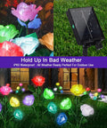 4 Pack Solar Rose Garden Lights With 7 Color Changing LEDs Waterproof Outdoor Lights in rain, vibrant colors in flower bed.