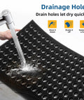 Water running over Heavy Duty Outdoor Doormat with All Weather Waterproof Construction Non Slip Drainage Entry Mat For Garage Home Pool Or Commercial Use Dirt Trapper Welcome Rug 17 By 29.5 Inches Black showing drainage holes.