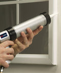 Person using Pneumatic Caulk Gun For 10.1 Fl Oz Cartridges, Smooth Controlled Dispensing on window frame.