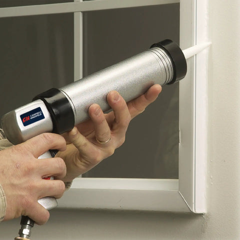 Person using Pneumatic Caulk Gun For 10.1 Fl Oz Cartridges, Smooth Controlled Dispensing on window frame.