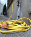 Heavy Duty 12/3 Gauge 100-Foot Extension Cord With Power Indicator Light, Kink-Resistant SJTW Indoor Outdoor Yellow coiled outdoors