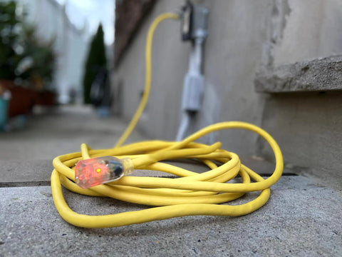 Heavy Duty 12/3 Gauge 100-Foot Extension Cord With Power Indicator Light, Kink-Resistant SJTW Indoor Outdoor Yellow coiled outdoors