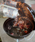 Charcoal being poured into Smokey Joe 14 Inch Portable Charcoal Grill With Tuck N Carry Lid Lock And Durable Porcelain Enamel Finish for BBQ