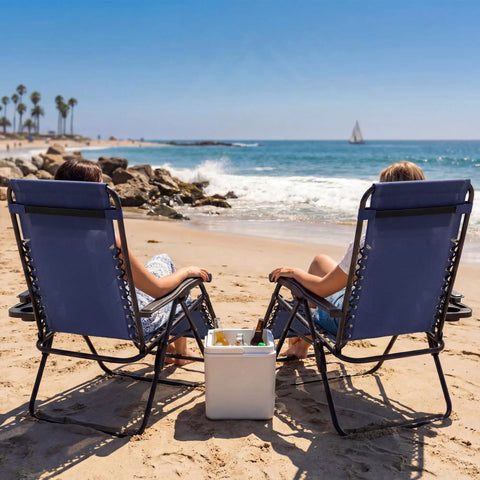 Two Blue Zero Gravity Lounge Chairs Set With Cup Holders And Pillows on a sandy beach facing the ocean