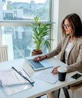 Woman working at a desk with laptop, coffee cup, and 12 Pack Waterproof Zipper File Folders with Tear-Resistant PVC Pouches