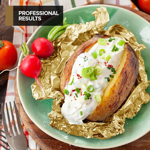 Baked potato topped with sour cream and chives placed on a heavy duty aluminum foil sheet.