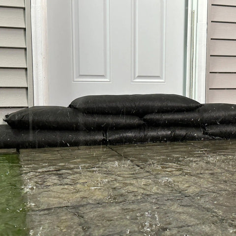 Flood protection with Grab And Go Flood Kit with 20 Water Activated Flood Bags, blocking flood water at a door entrance.