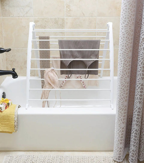 Freestanding Indoor Clothes Drying Rack Foldable Garment Hanger Compact Space Saving Design Lightweight White Finish with drying clothes.