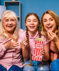 Three happy family members enjoying popcorn in red-striped Heavy Duty Paper Popcorn Bags 1 Oz Individual Servings at home