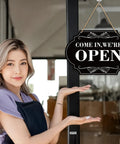 Woman pointing to Waterproof Double Sided Open Or Closed Sign For Business With Rope Hanging Sign 11.8 By 7.9 Inches on door