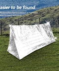 Emergency Survival Reflective Blanket For Camping And Hiking Packable Thermal Shield Multipurpose Tent on grassy field