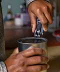 Close-up of blue Gerber Prybrid multi-tool with pocket clip being used to pry open a can