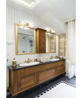 Bathroom with wooden vanity and mirrors under Caper 24 Inch LED Vanity Light In Brushed Brass With Frosted Lens Dimmable Hardwired Fixture