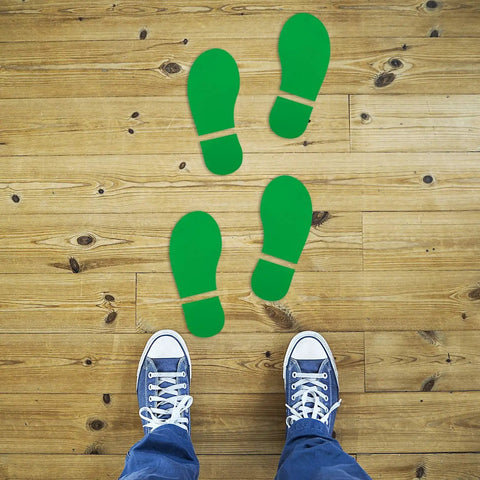 Floor view of green footprint stickers from 45 Pairs 90 Footprint Floor Stickers Set for Classrooms and Dance Studios Waterproof PVC Decals.