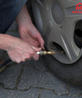 No Sweat Quarter Inch Tire Inflator Extension Hose With Fast Grip Self Locking Chuck and High Pressure Air Tube in use on a car tire.