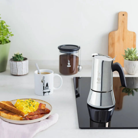 New Venus Induction Stovetop Coffee Maker 6 Cup Stainless Steel Silver on modern kitchen counter next to breakfast and plants