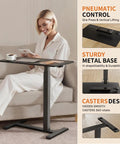 Mobile Standing Desk With Wheels Height Adjustable Pneumatic Laptop Desk Overbed Table in use by woman, black metal