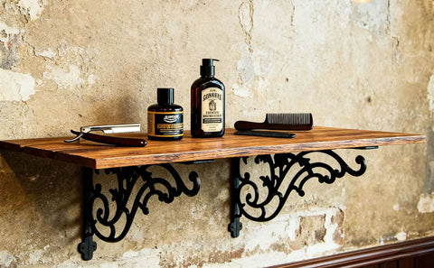 16 Inch Cast Iron Shelf Brackets 4 Pack Black Corbels Built Different Heavy Duty Wall Mounted Shelf Supports Up To One Hundred Pounds With Mounting Hardware holding grooming products on a wooden shelf.